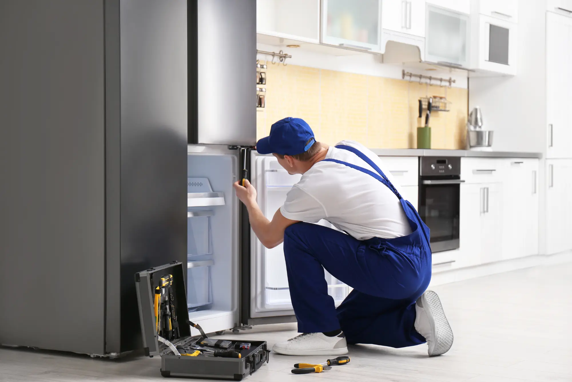 Friendly appliance technician preparing to service a residential refrigerator